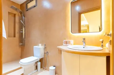 a bathroom with a toilet and a sink and a mirror at Villa Meraki in Marrakech