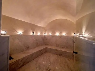 a bathroom with a tub with lights on the wall at Villa Tiaré Luxury, pool, staff and private cinema in Marrakech