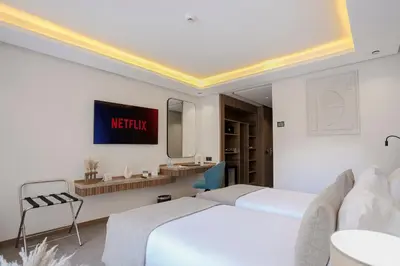 a hotel room with two beds and a mirror at NearYo Hotels in Marrakech