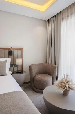 a bedroom with a bed and a chair and a table at NearYo Hotels in Marrakech
