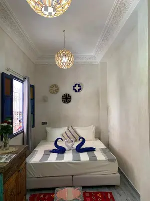 a bedroom with a bed with blue towels on it at Riad Zifamo in Marrakech