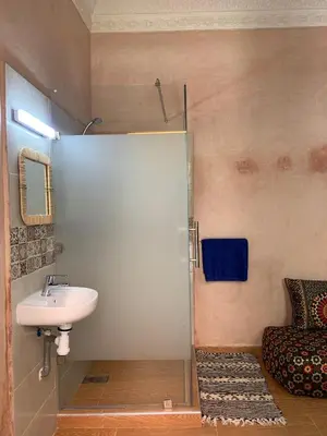 a bathroom with a sink and a shower stall at Riad Zifamo in Marrakech