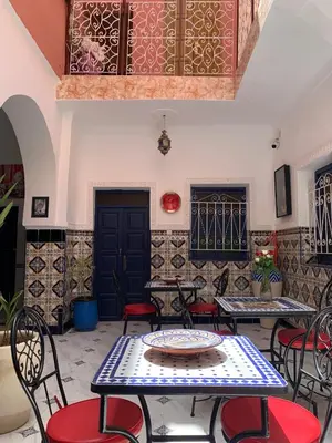 a patio with tables and chairs in a building at Riad Zifamo in Marrakech