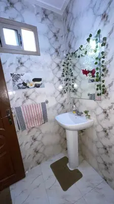a bathroom with a white sink and marble walls at Marrakech,Massira1 in Marrakech