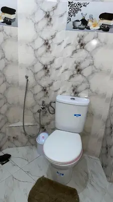 a white bathroom with a toilet and a shower at Marrakech,Massira1 in Marrakech