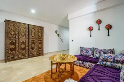 a living room with a purple couch and a table at Marrakech Duplex Haut Standing, Piscine et Jardin Privé in Marrakech