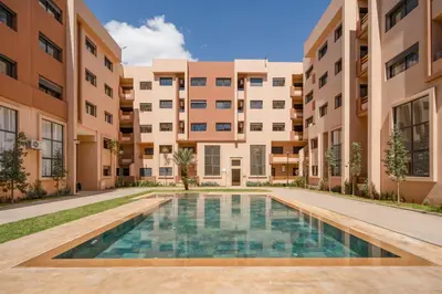an apartment complex with a swimming pool in the courtyard at Marrakech Duplex Haut Standing, Piscine et Jardin Privé in Marrakech