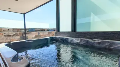 a swimming pool in a room with a large window at Duplex Cheryn Heated rooftop pool in Marrakech