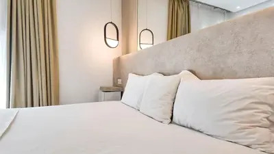 a bedroom with a white bed with two pillows at Duplex Cheryn Heated rooftop pool in Marrakech
