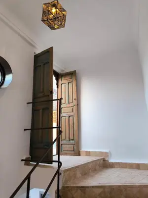 a pair of wooden doors in a room with stairs at Riad MAGE Marrakech in Marrakech