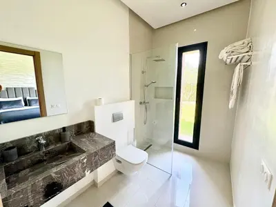 a bathroom with a toilet and a sink and a mirror at Villa exclusive Ourika piscine sans vis-à-vis in Segraga