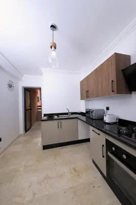 a kitchen with white walls and black counter tops at 2 Bedroom flat - Marrakech in Marrakech
