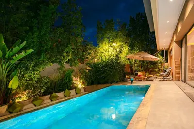 a swimming pool in a garden at night at Villa Aria Marrakech in Marrakech