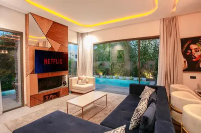 a living room with a couch and a tv at Villa Aria Marrakech in Marrakech