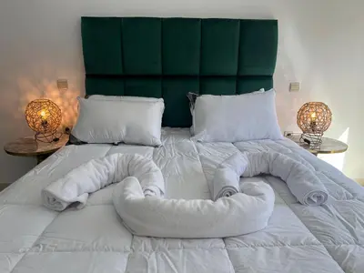 a large white bed with towels on it at Super apt plein centre de Gueliz hyper bien placer pour votre séjour tout à proximité resto café transport in Marrakech