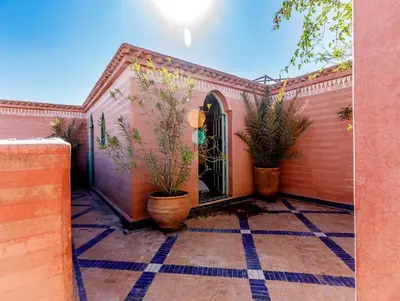 a house with two potted plants on a patio at Riad Bleu-Azrak in Marrakech