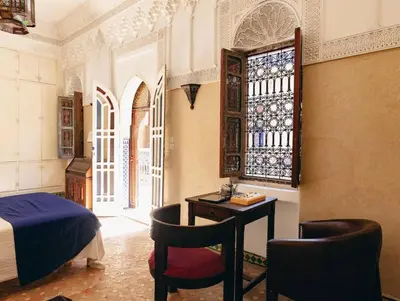 a bedroom with a bed and a desk and a window at Riad Bleu-Azrak in Marrakech