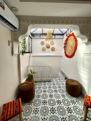 a room with a tile floor and two stools at Dar Salomi in Marrakech