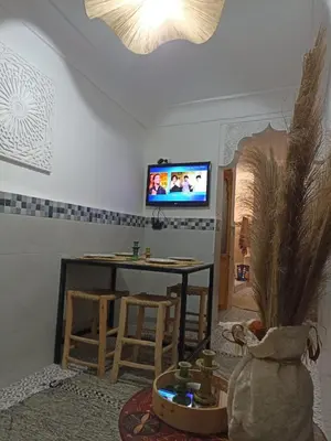 a living room with a table and a tv at Maison en exclusivité 2 chambre Place Jemma El Fna in Marrakech