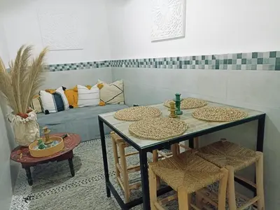 a dining room with two tables and a couch at Maison en exclusivité 2 chambre Place Jemma El Fna in Marrakech