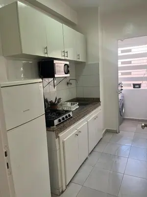 a kitchen with white cabinets and a stove top oven at appartement sadaa in Marrakech