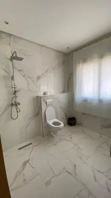 a white bathroom with a toilet and a shower at VILLA MARRAKECH - Centre Ville in Marrakech