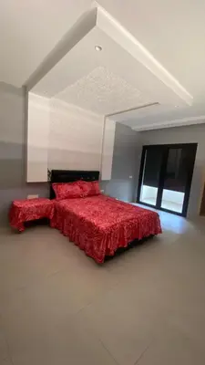 a bedroom with a bed with a red comforter at VILLA MARRAKECH - Centre Ville in Marrakech