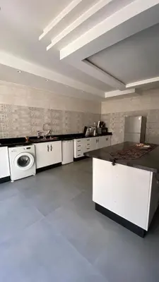 a large kitchen with white cabinets and a dishwasher at VILLA MARRAKECH - Centre Ville in Marrakech