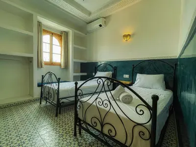 a bedroom with two beds and a window at Antaki retreat Marrakech in Marrakech