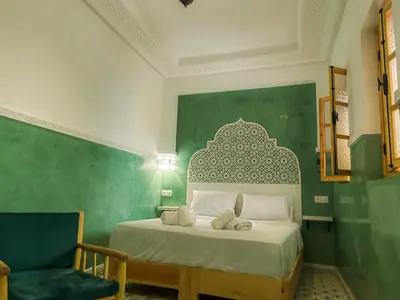 a bedroom with a bed with a green wall at Antaki retreat Marrakech in Marrakech