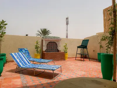 two chairs sitting on a patio with a fireplace at Antaki retreat Marrakech in Marrakech