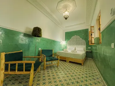 a bedroom with a bed and a chair and a couch at Antaki retreat Marrakech in Marrakech
