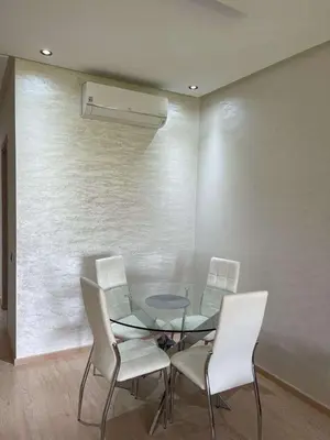 a dining room with a glass table and white chairs at Le villagois in Marrakech