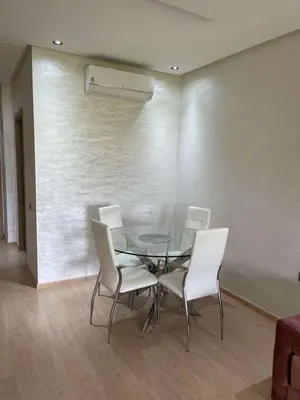 a dining room with a glass table and white chairs at Le villagois in Marrakech