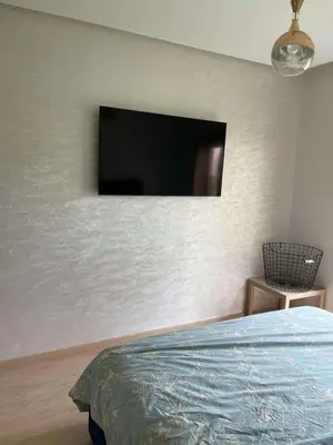 a bedroom with a flat screen tv on the wall at Le villagois in Marrakech