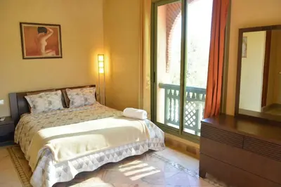 a bedroom with a bed and a dresser and a window at Palmeraie Stay - Pool & Lake in Marrakech