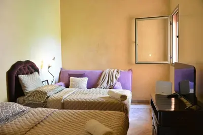 a bedroom with two beds and a mirror on the wall at Palmeraie Stay - Pool & Lake in Marrakech