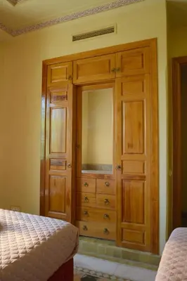 a wooden dresser with a mirror in a bedroom at Palmeraie Stay - Pool & Lake in Marrakech