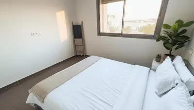 a bedroom with a large white bed with a window at Central Cozy Kesh - Pool - Terrace in Marrakech