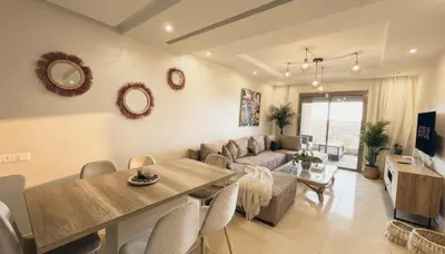 a living room with a couch and a dining room at Central Cozy Kesh - Pool - Terrace in Marrakech