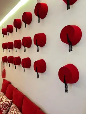 a wall with red hats on a wall at Riad Miliana in Marrakech