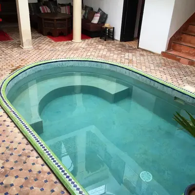 a swimming pool with blue water in a house at Riad Miliana in Marrakech