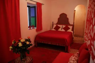 a bedroom with a red bed and a vase of flowers at Riad Miliana in Marrakech
