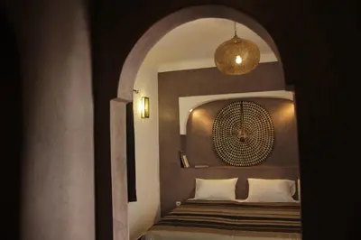 a bedroom with a bed in a room with an archway at Riad Miliana in Marrakech