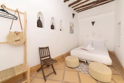 a bedroom with a bed and a chair and a table at Riad Privé Dar El Khamsa-Petit Dej inclus in Marrakech