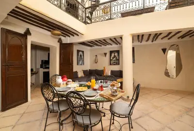 a dining room with a table and chairs and a couch at Riad Privé Dar El Khamsa-Petit Dej inclus in Marrakech