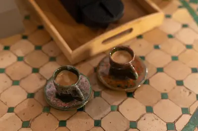 two cups sitting on the floor of a bathroom at Riad Privé Dar El Khamsa-Petit Dej inclus in Marrakech