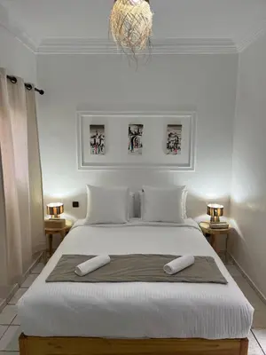 a bedroom with a large white bed with two towels on it at RIAD Al QARYA 4 chambres in Marrakech