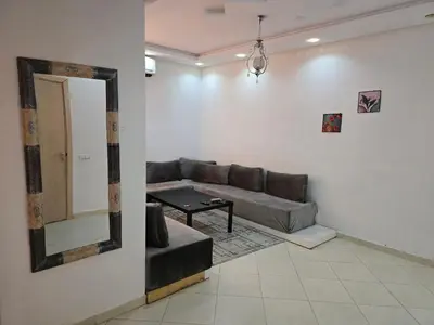 a living room with a couch and a mirror at Appartement Meublé 2 Chambres avec Wi-Fi Haut Débit in Marrakech