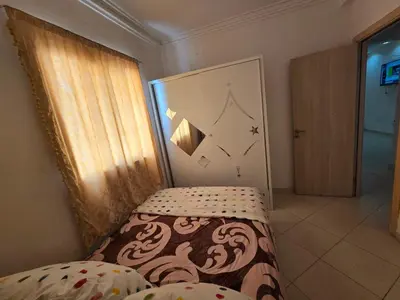 a bedroom with a bed and a door with a curtain at Appartement Meublé 2 Chambres avec Wi-Fi Haut Débit in Marrakech